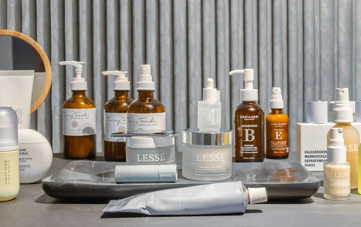 Collection of Lesse and other natural skincare products including moisturizers, serums, and enzyme cleansing oils on tray.