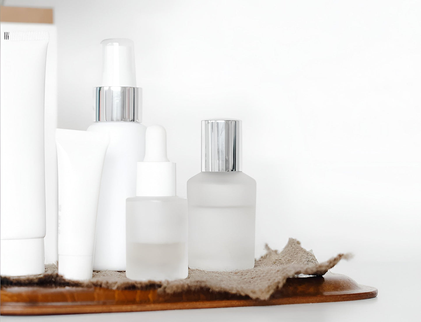 Minimal white skincare bottles and serums on a tray, featured by Sommetbeauty.