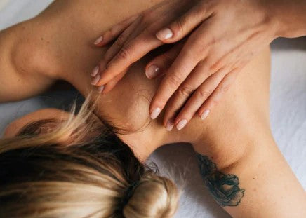 A woman receiving a relaxing shoulder massage from a therapist.