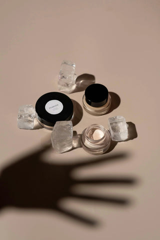 Sommetbeauty skincare powders and creams styled with ice cubes on a beige background.