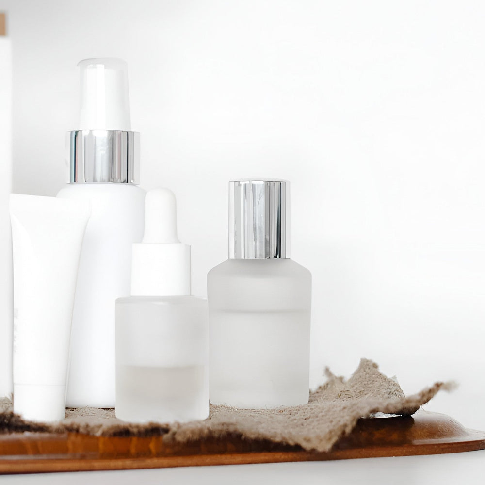 Minimal white skincare bottles and serums on a tray, featured by Sommetbeauty.