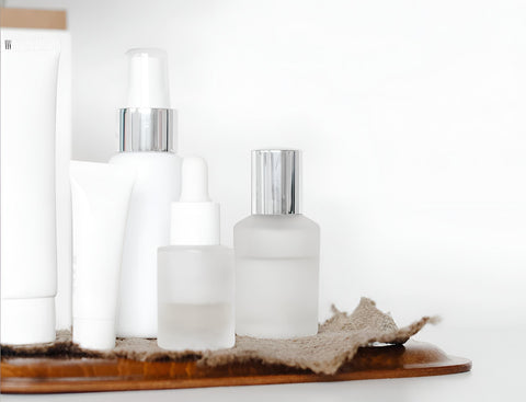 Minimal white skincare bottles and serums on a tray, featured by Sommetbeauty.